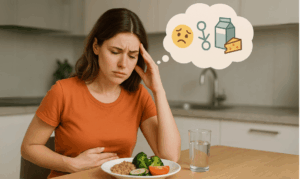 woman wearing orange shirt feeling bloated after eating fiber and water. She's thinking what she'd do instead